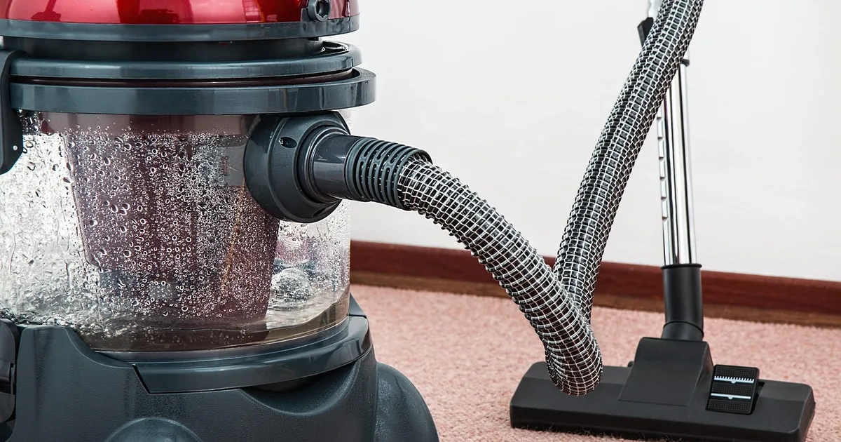 Cordless stick vacuum standing on a hardwood floor