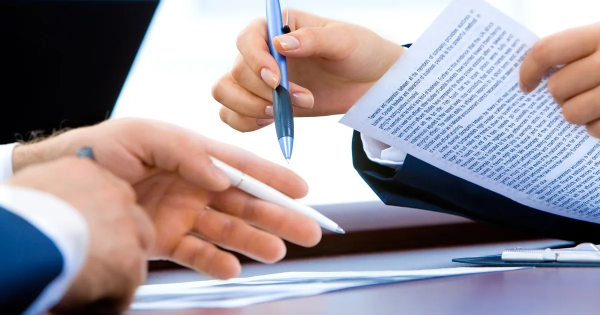 Executive desk with signed deferred compensation documents and a pen