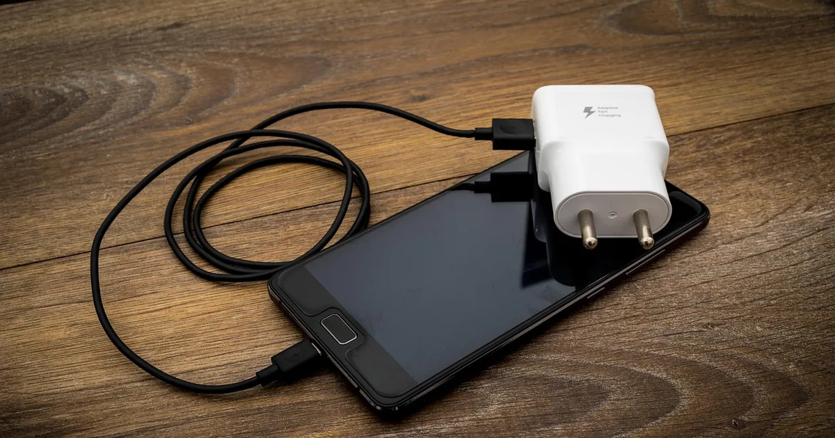 테이블 위에 놓인 USB-C 케이블과 휴대폰 충전기